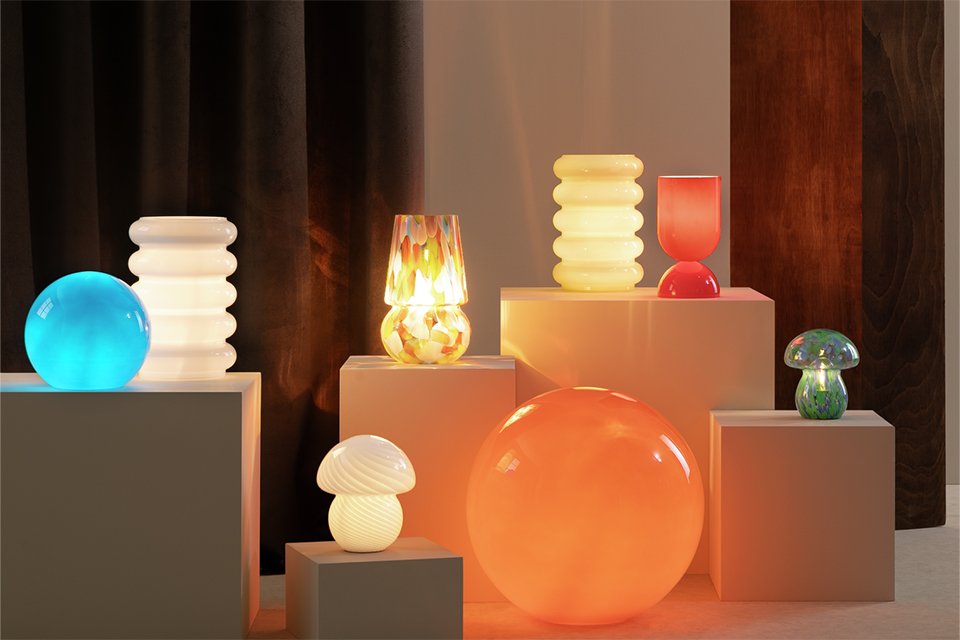 Range of lighting showcase on platfroms in warm colours and geometrical shaped lighting.